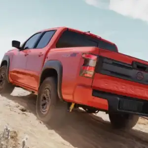 2026 Nissan Frontier PRO-4X Afterburn Orange driving uphill