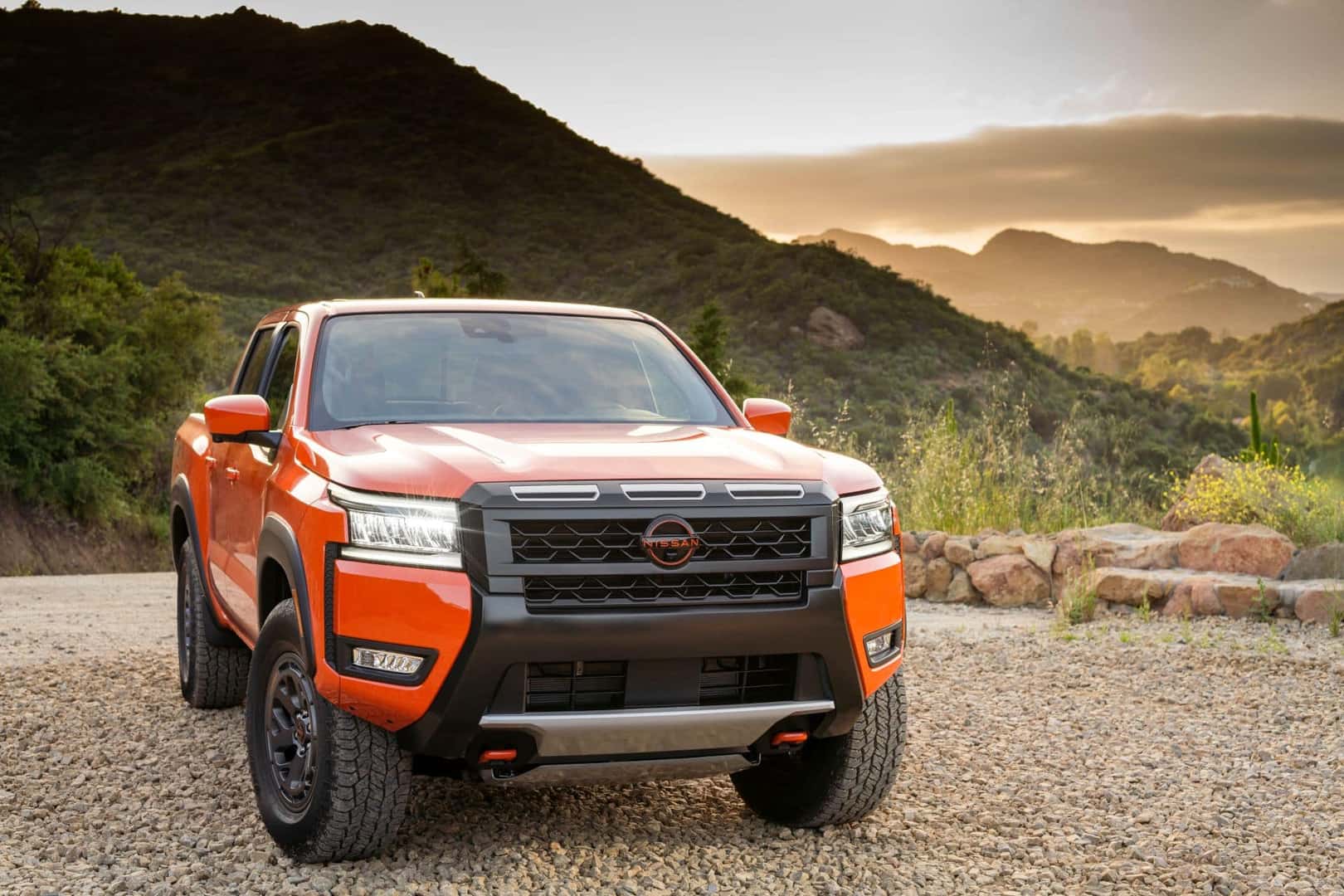 The Bright Orange Front Profile Of The Fantastic 2025 Nissan Frontier Pickup Truck