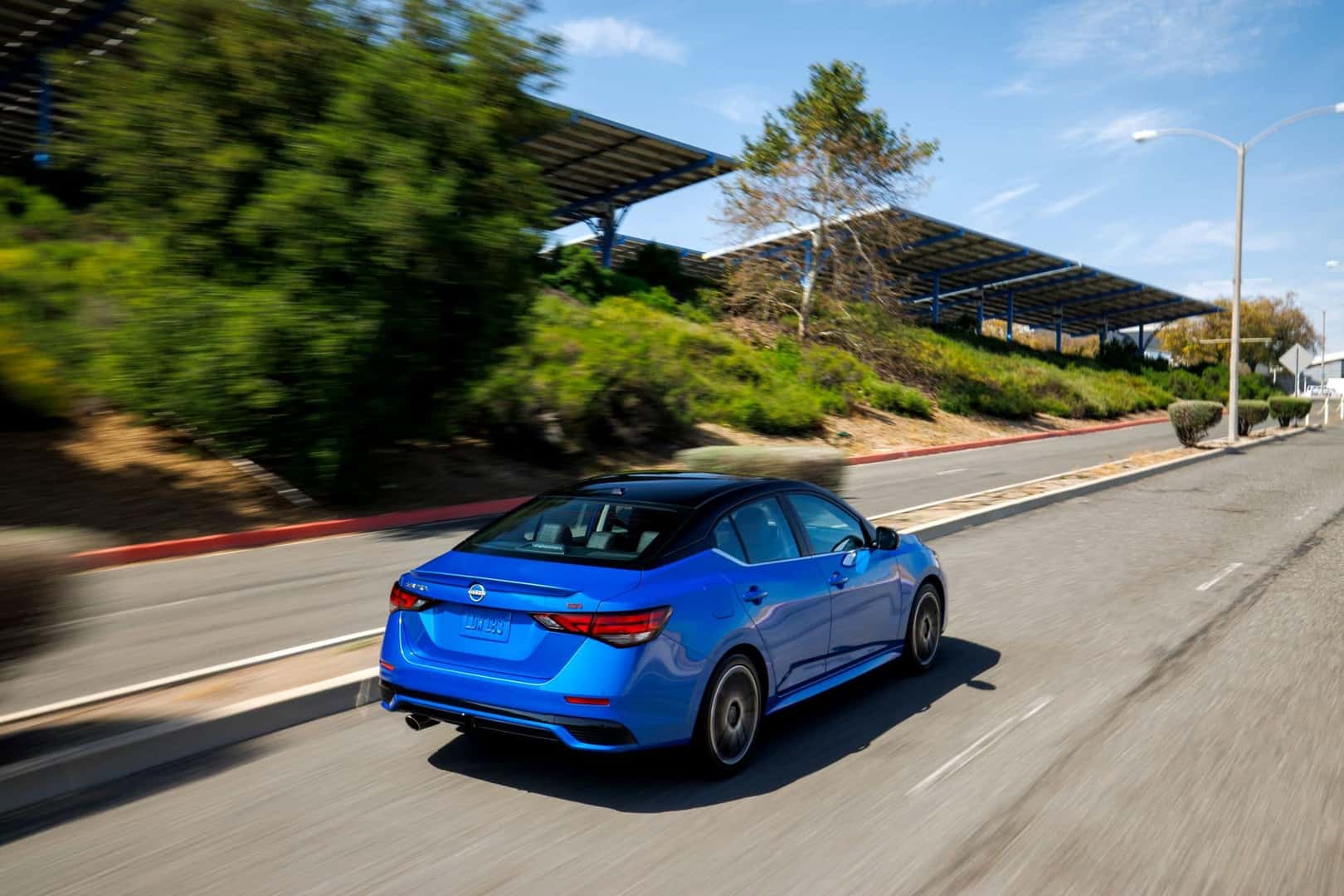 The Fuel Effecient 2025 Nissan Sentra's Back Profile Driving At A Safe Speed
