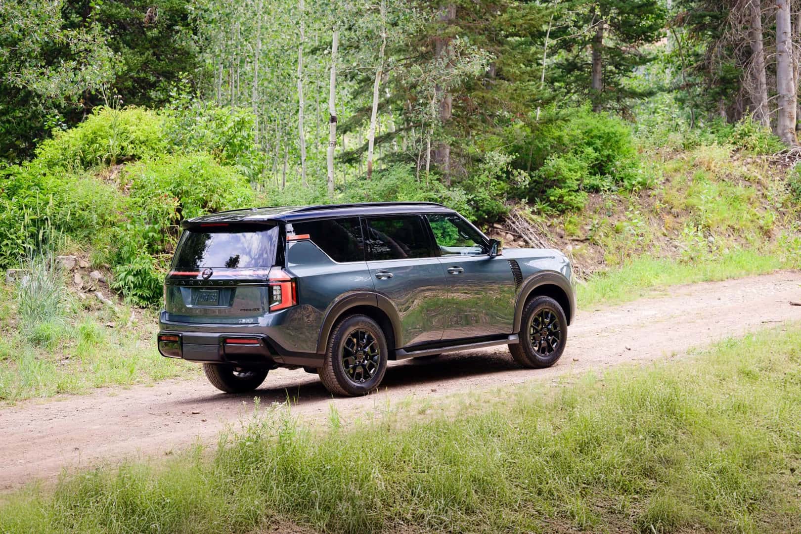 The Reflective Silver 2025 Nissan Armada Journeying Through A Sparse Forest