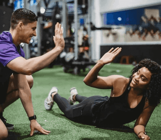 Two People High-Fiving at Gym