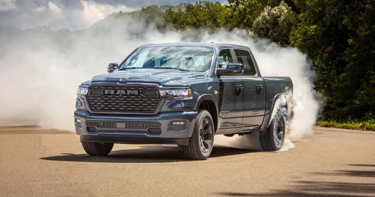 A black Ram 1500 pickup truck performing a burnout.