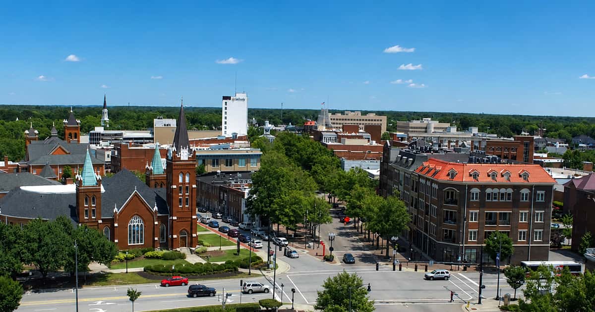 An elevated view of downtown Fayetteville, North Carolina, highlighting the historic St. Joseph's Episcopal Church on the left and the intersection of Hay Street and Gillespie Street.