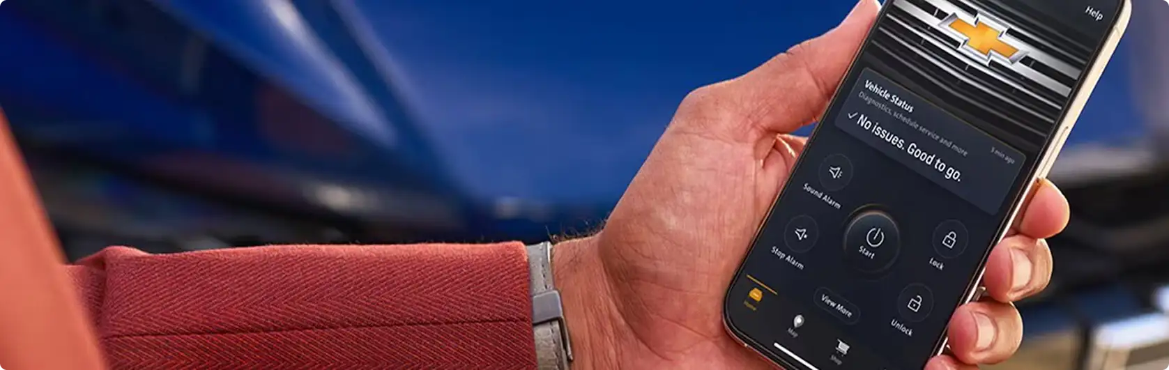 Driver holding a phone running the OnStar app inside an Equinox