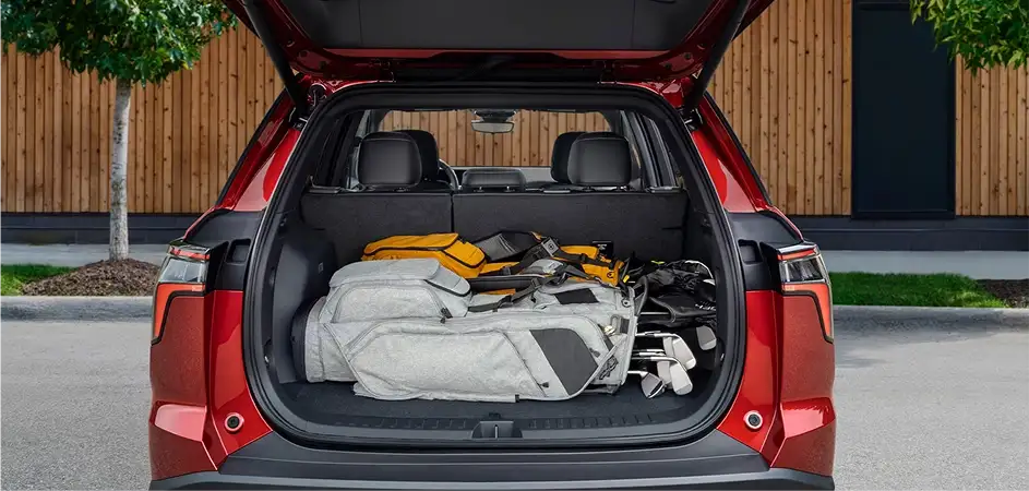 Red 2027 Chevrolet Equinox with rear liftgate open showing cargo loaded with gear