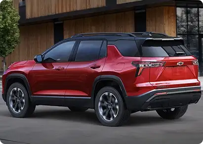 Red Chevrolet Equinox rear three-quarter view beside a wood-paneled building