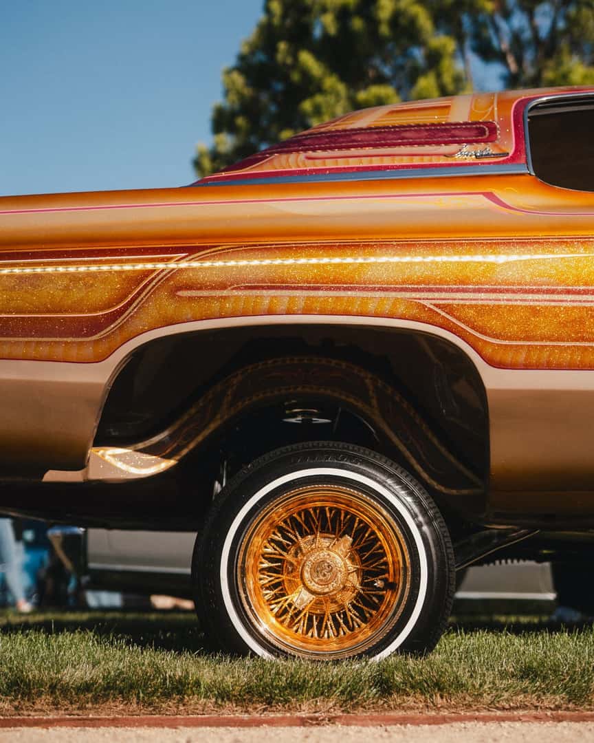 Custom lowrider with gold wire wheel at the Felix Chevrolet Classic Car Show