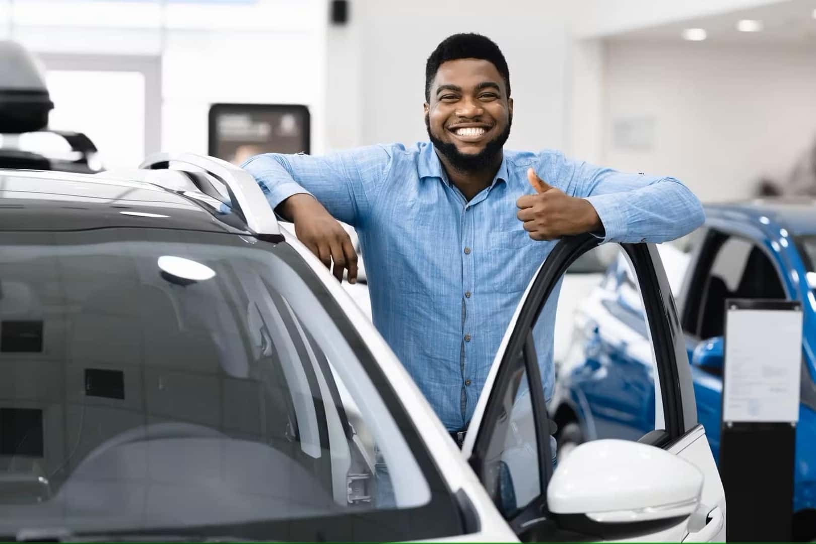 Customer standing next to new vehicle and giving a thumbs up