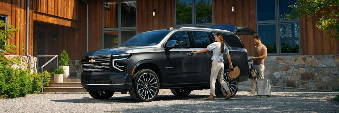 Couple packing 2026 Chevy Tahoe in driveway