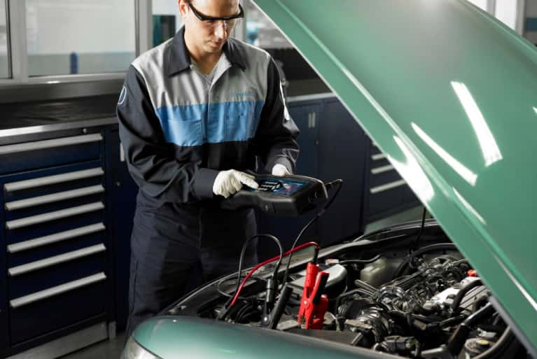 Honda-service-technician-checking-on-the-voltage-level-of-car-engine