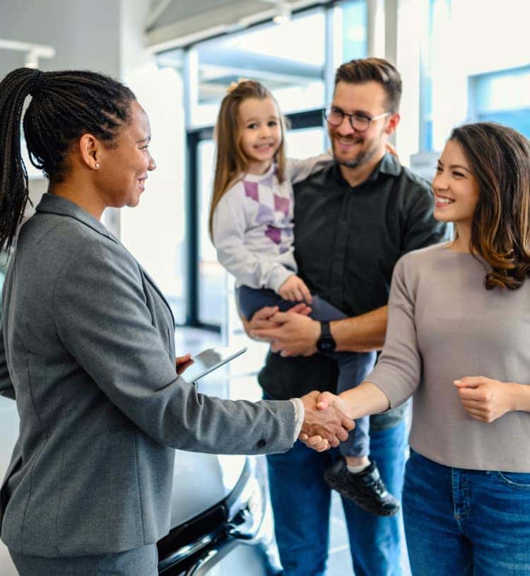 Mother with her family shaking hands with Frank Leta Buick GMC Employee