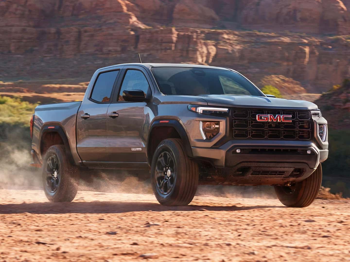 2025 GMC Canyon driving confidently through a rugged landscape.