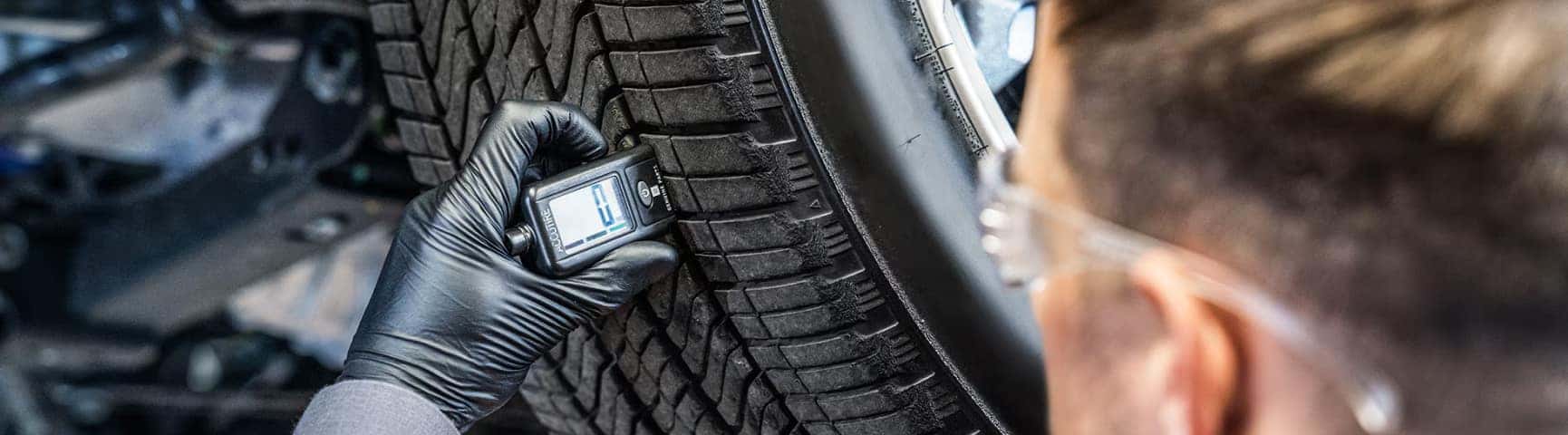 Technician checking tire tread