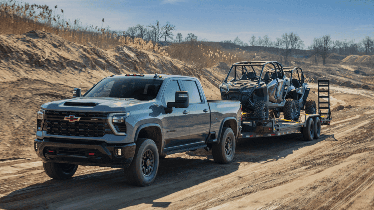 2024 Chevrolet Silverado 2500 HD towing off-road vehicles through rugged terrain, showcasing its powerful towing capabilities. Featured in Forest City’s Guide to Towing 2024 Chevrolet Silverado 2500 HD towing off-road vehicles through rugged terrain, showcasing its powerful towing capabilities. Featured in Forest City’s Guide to Towing