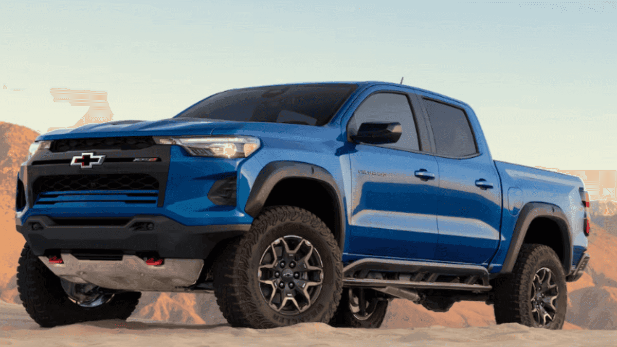 Exterior front three-quarter view of a blue 2026 Chevrolet Colorado with off-road tires and rugged stance in a desert landscape