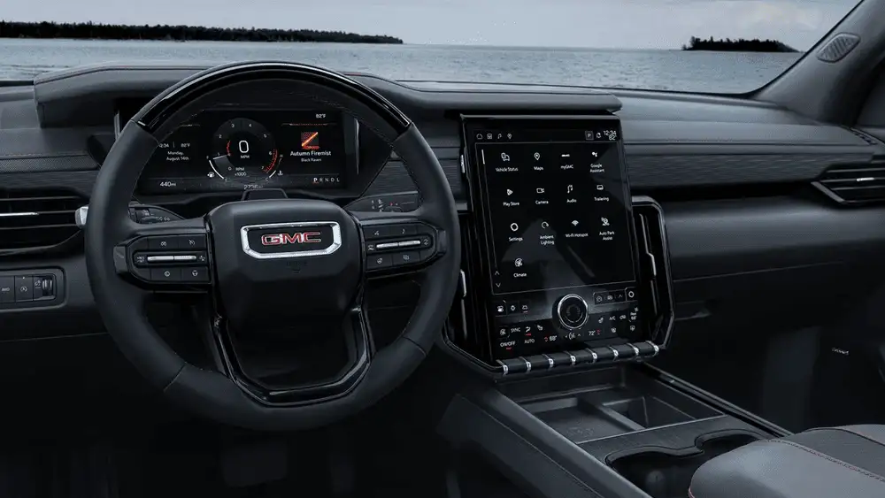 Interior driver cockpit of a 2026 GMC Acadia with a large vertical touchscreen, digital displays, and modern dashboard layout near Ruth, NC