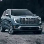 2026 GMC Acadia parked on open terrain, showcasing bold SUV styling, family-ready space, and power for drivers in Ruth, NC