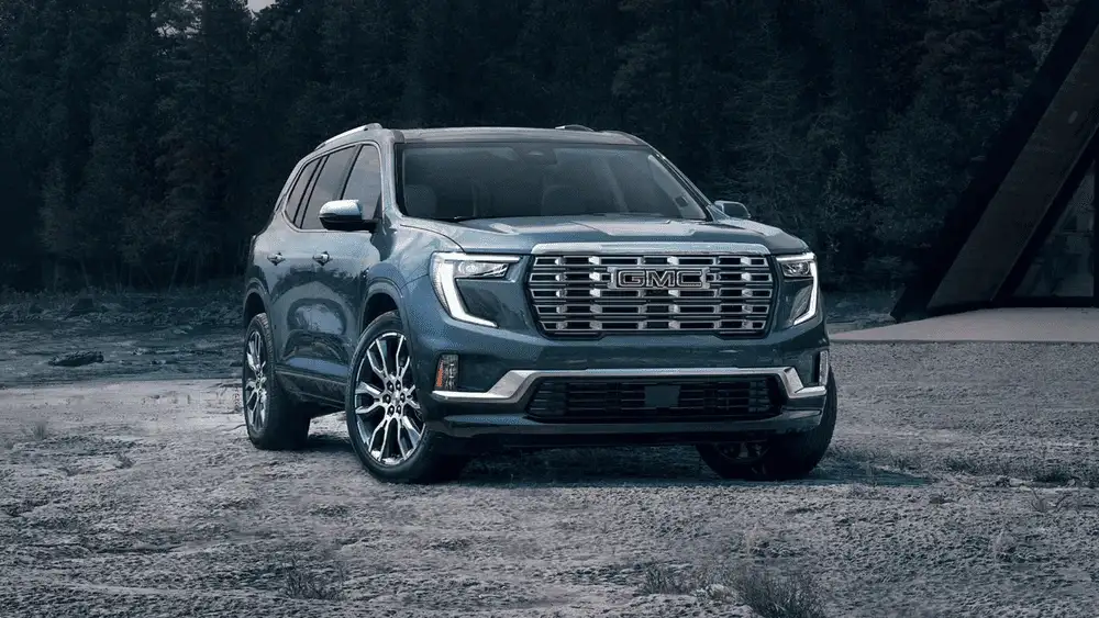 2026 GMC Acadia parked on open terrain, showcasing bold SUV styling, family-ready space, and power for drivers in Ruth, NC