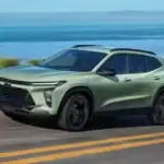 Green 2026 Chevrolet Trax driving along a coastal highway, showcasing turbo engine performance for roads around Ruth NC