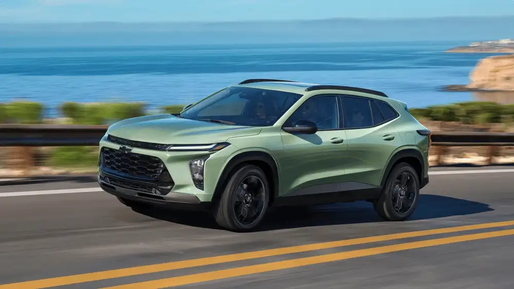 Green 2026 Chevrolet Trax driving along a coastal highway, showcasing turbo engine performance for roads around Ruth NC