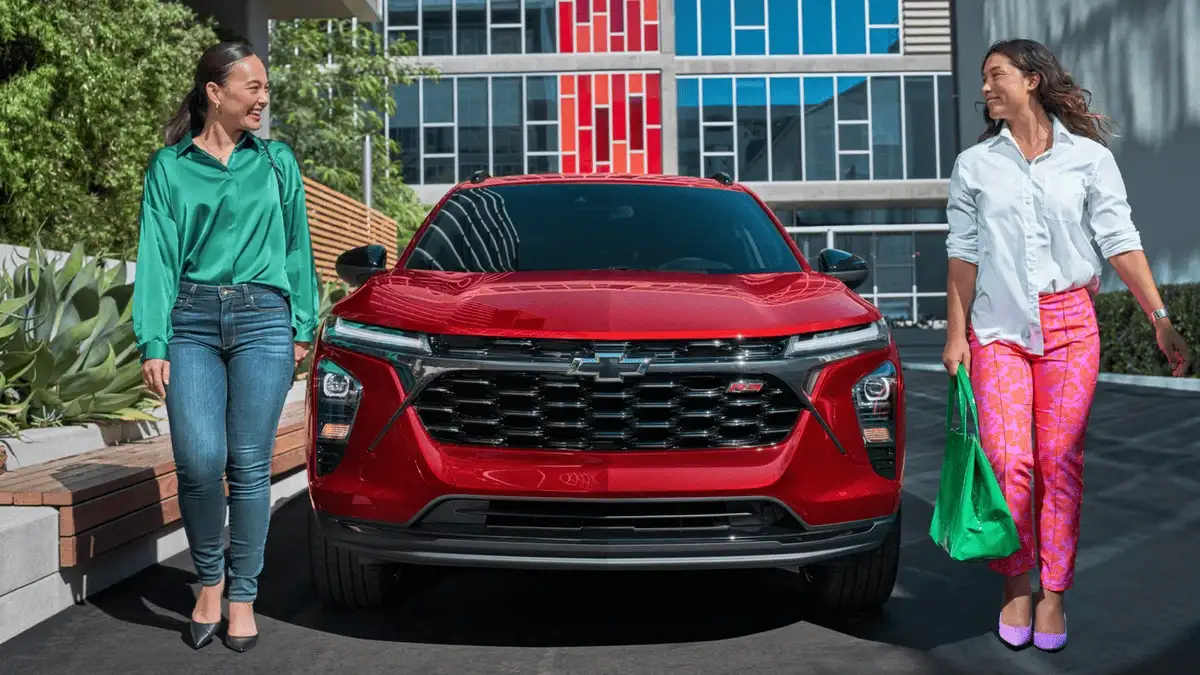 Front view of red 2026 Chevrolet Trax near Ruth, NC parked in a city setting, showcasing sporty grille design and compact SUV styling