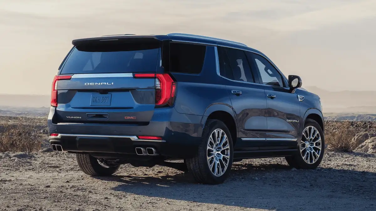 Rear view of 2026 GMC Yukon near Ruth, NC parked on rugged terrain, highlighting Denali trim details and spacious full-size SUV design