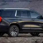 Black 2026 GMC Yukon Denali parked on rugged terrain, highlighting spacious SUV comfort for family travel near Ruth NC