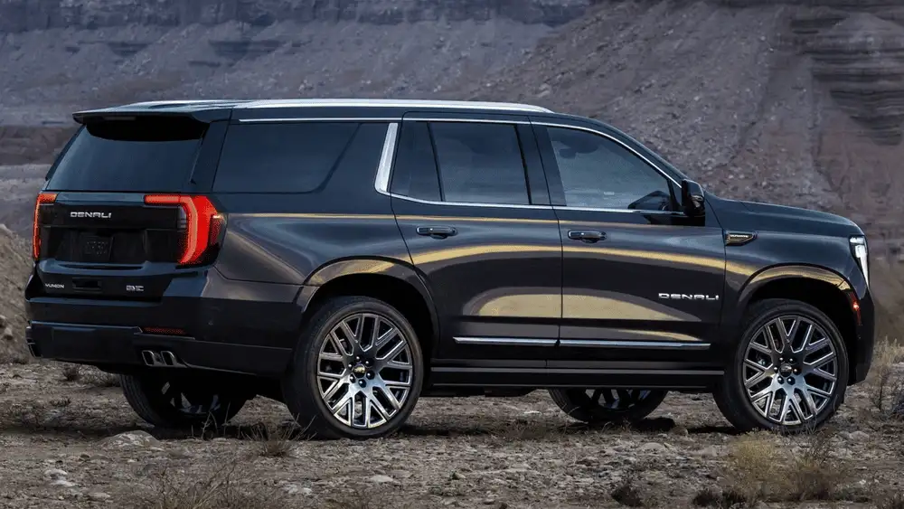 Black 2026 GMC Yukon Denali parked on rugged terrain, highlighting spacious SUV comfort for family travel near Ruth NC