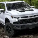 White 2026 Chevrolet Silverado ZR2 parked on a forest trail, emphasizing off-road capability for drivers near Ruth NC