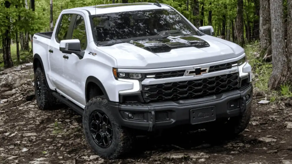 White 2026 Chevrolet Silverado ZR2 parked on a forest trail, emphasizing off-road capability for drivers near Ruth NC