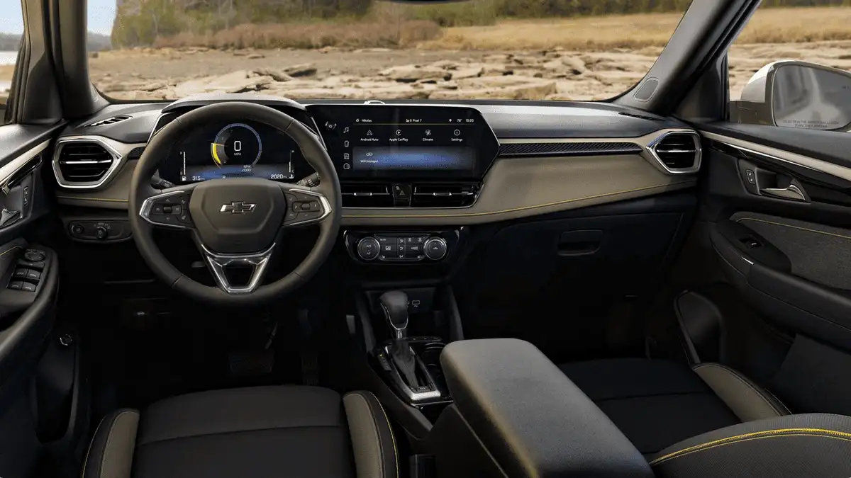 2026 Chevrolet Trailblazer interior dashboard near Ruth NC with digital instrument cluster, touchscreen infotainment, black and gold accent seats, and automatic gear shifter