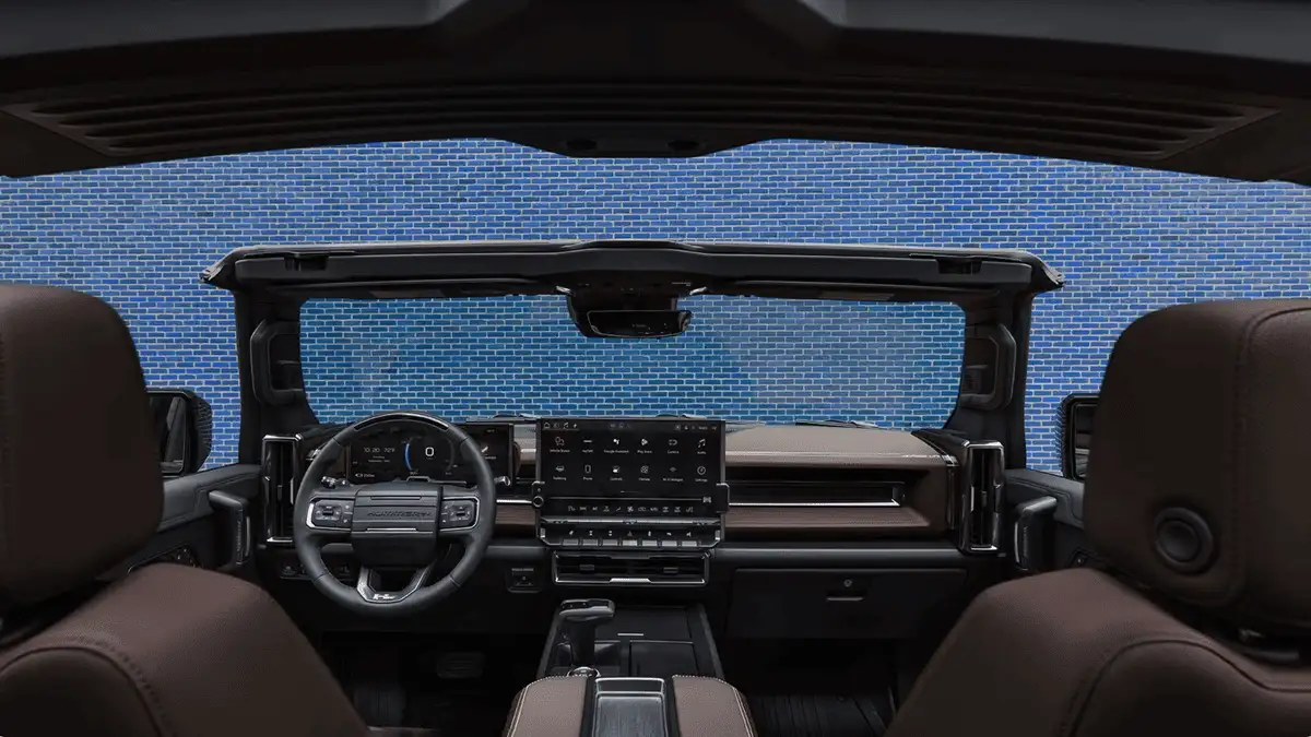 2026 GMC Hummer EV SUV interior near Ruth NC with removable open-air roof panels, large center touchscreen, brown leather seats, and Hummer-branded steering wheel