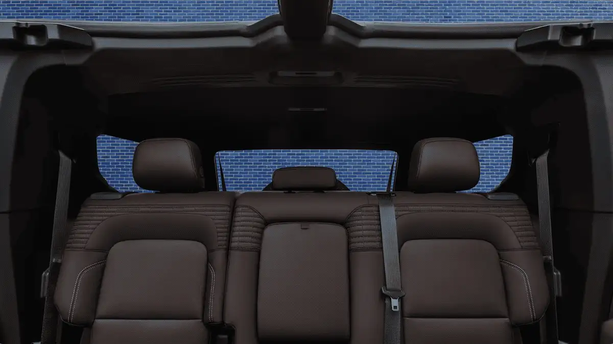 2026 GMC Hummer EV SUV rear seating near Ruth NC featuring three-passenger brown leather bench with open sky roof panel and seatbelt visible