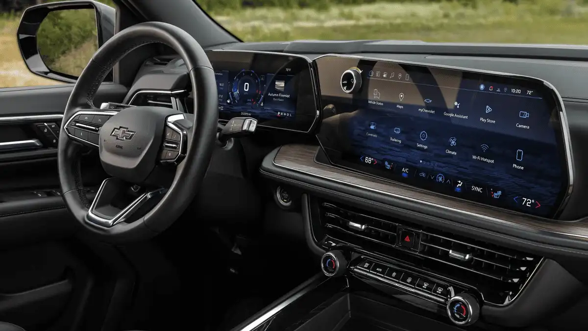 2026 Chevrolet Suburban interior dashboard near Ruth NC with Bowtie steering wheel, large dual touchscreen infotainment display showing Google Assistant and Play Store, and wood trim accents