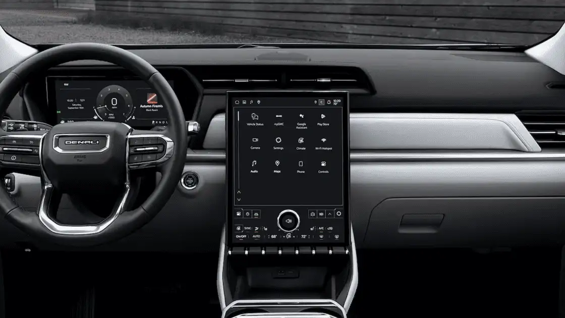 2026 GMC Terrain Denali interior dashboard near Ruth NC with Denali-branded steering wheel, large vertical center touchscreen showing Google Assistant and myGMC, and dual-zone climate controls