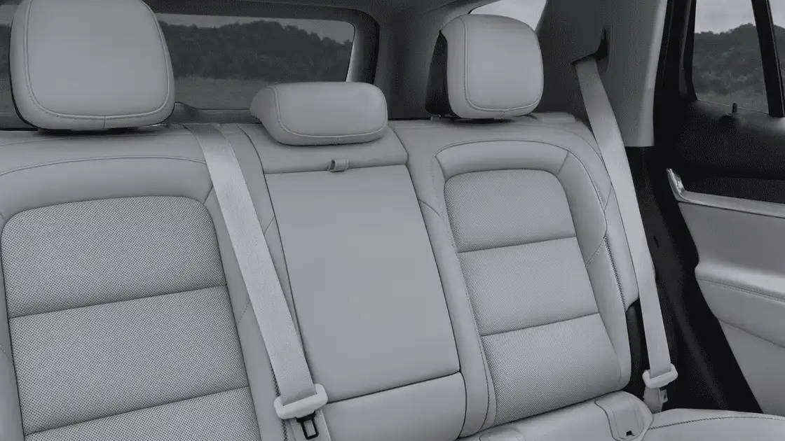2026 GMC Terrain Denali rear passenger cabin near Ruth NC with light gray leather bench seating, headrests, and seatbelts visible against a hillside landscape