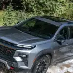 2026 Chevrolet Traverse Z71 near Ruth NC in gray with Bowtie grille and black wheels fording a stream
