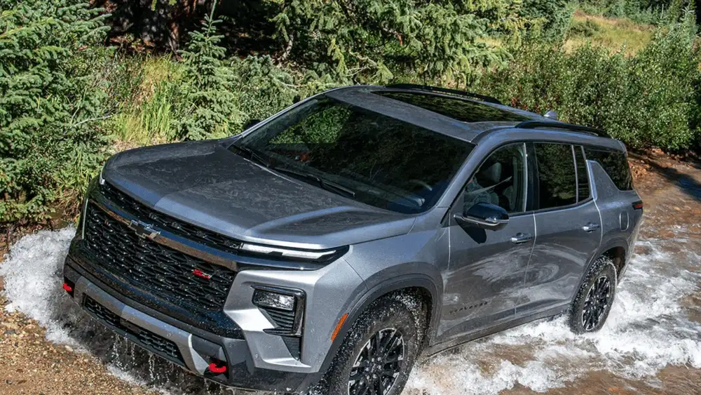 2026 Chevrolet Traverse Z71 near Ruth NC in gray with Bowtie grille and black wheels fording a stream
