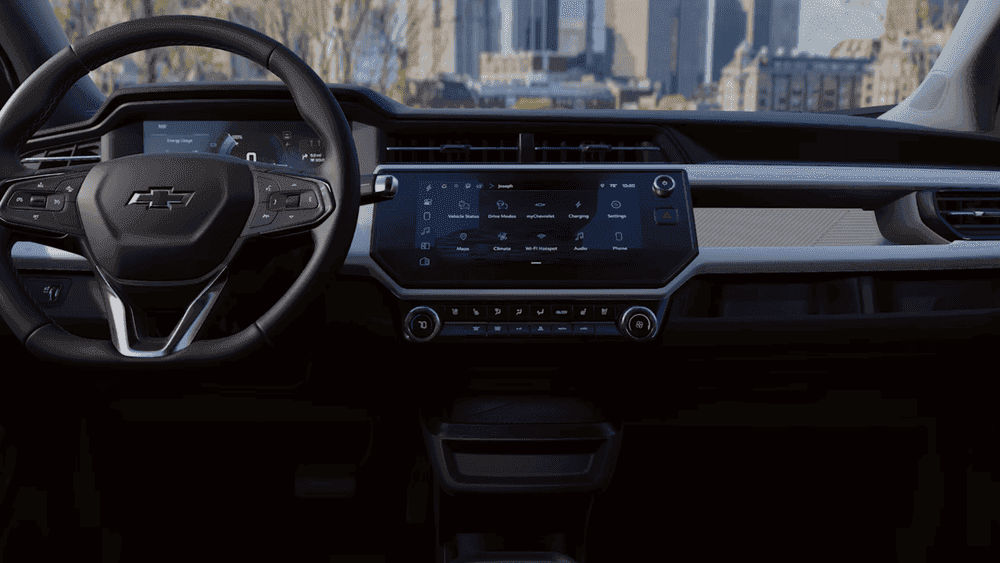 2027 Chevrolet Bolt dashboard near Ruth NC with Bowtie steering wheel and touchscreen showing Drive Modes and Charging