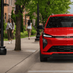 2027 Chevrolet Bolt RS near Ruth NC in red with Bowtie grille and LED headlights parked on a tree-lined urban street