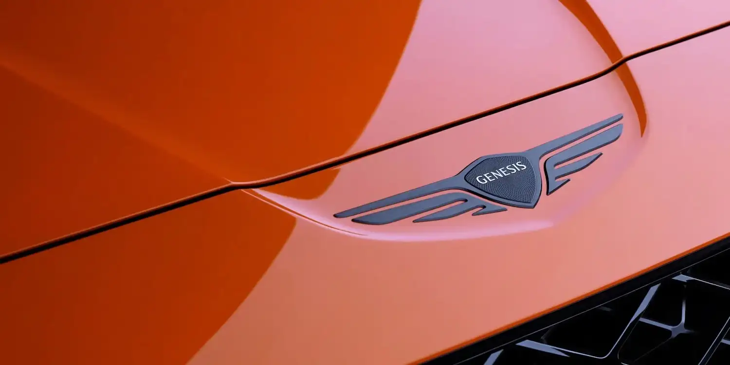 Close-up of the Genesis wing badge on Magma Orange bodywork