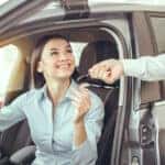 Young woman sitting in a car test drive rental service