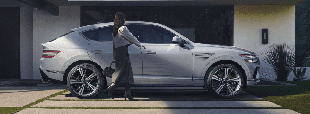 Silver 2026 Genesis GV80 Coupe outside home with women opening the door.