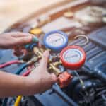 Technician inspecting A/C at a Genesis service appointment