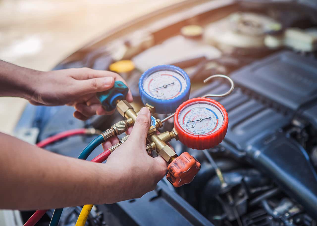 Technician inspecting A/C at a Genesis service appointment
