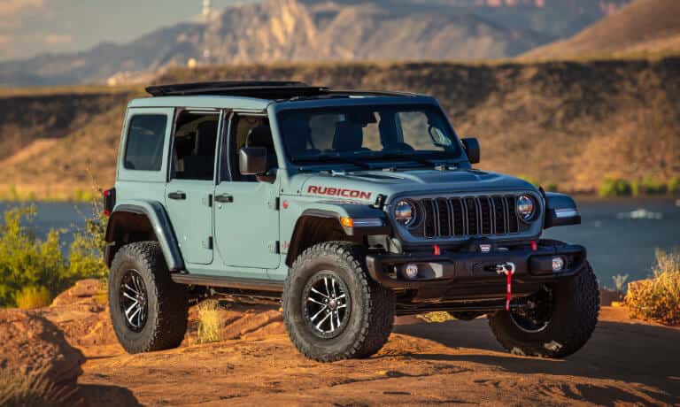 2026 Jeep Wrangler parked on lakeside rocks