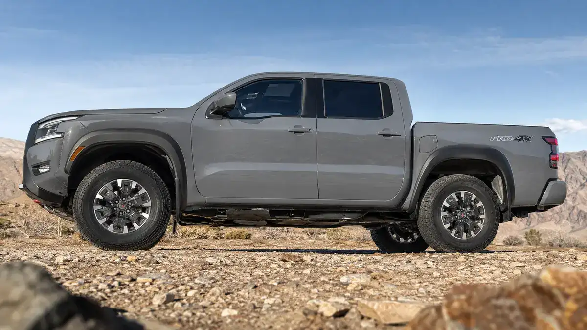 Side profile of a Nissan Frontier PRO-4X on rocks, showing ride height and underbody protection