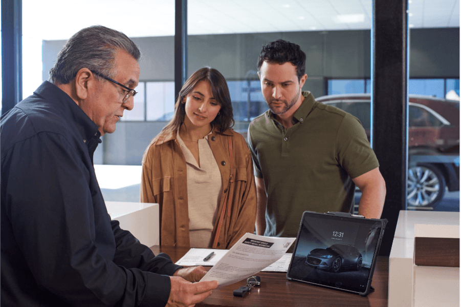 Goode Mazda finance team finalizing a vehicle purchase with customers in Twin Falls, Idaho