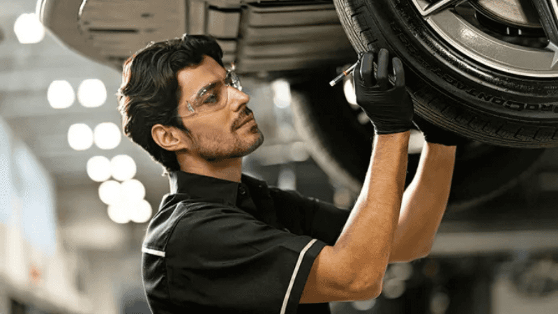 Technician inspecting a Mercedes-Benz tire before summer road travel