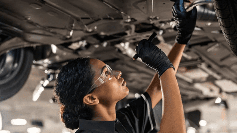 Mercedes-Benz Service Inspection in Grand Blanc Mercedes-Benz technician performing an underbody inspection during scheduled vehicle service